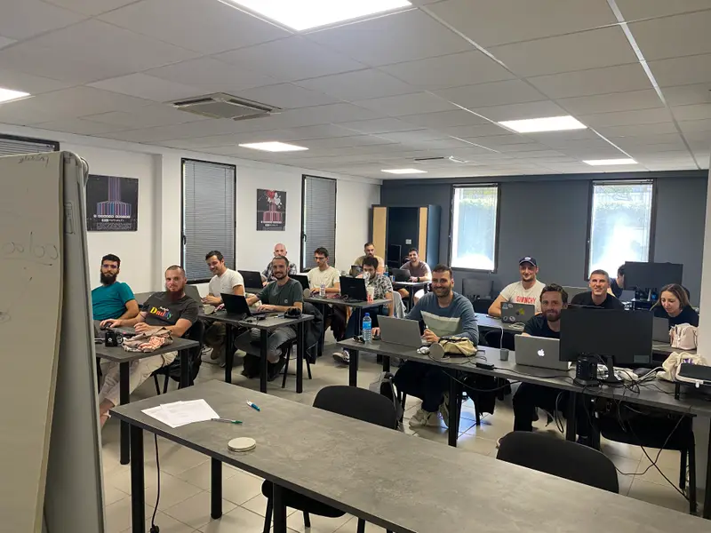 Une promotion en cours dans la salle de formation, ordinateurs ouverts