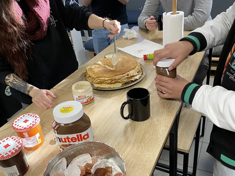 Petit-déjeuner de promotion : crêpes, pâte à tartiner et cafés sur la table